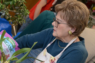 Retired woman pots plants indoors