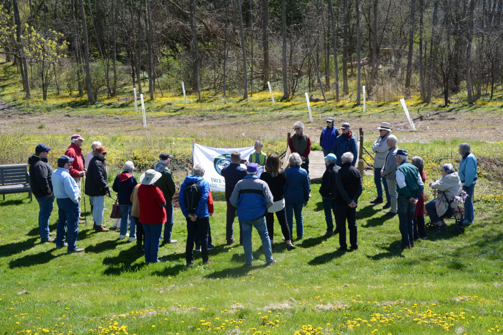 Members of the Community Forestry Project stand at a tree planting site to celebrate Kendal at Ithaca being recognized as a 2024 Tree Campus by the Arbor Day Foundation.